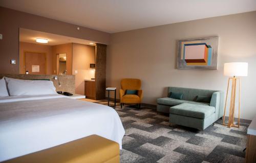 蒙克顿Hilton Garden Inn Moncton Downtown, Nb的酒店客房,配有一张床和两把椅子