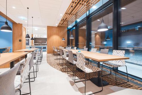 华沙Hampton By Hilton Warsaw Reduta的一个带桌椅的用餐室和一个游泳池