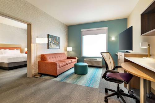 奥格登Home2 Suites By Hilton Ogden的酒店客房,配有一张床、一张桌子和椅子
