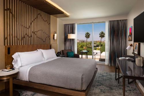斯科茨Canopy By Hilton Scottsdale Old Town的酒店客房设有一张床和一个大窗户