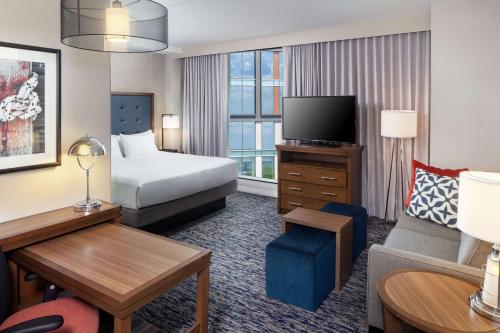 波士顿Homewood Suites by Hilton Boston Seaport District的一间酒店客房,配有一张床和一台电视