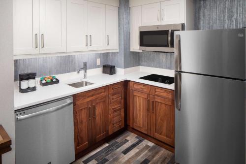 波士顿Homewood Suites by Hilton Boston Seaport District的厨房配有不锈钢冰箱和木制橱柜
