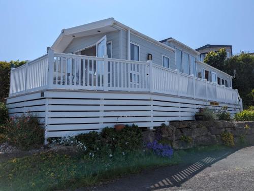 斯沃尼奇Caravan Swanage Bay View Holiday Park Dorset Amazing Location的大型白色房屋,设有大型门廊