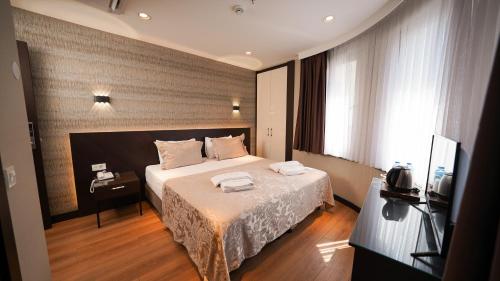 伊斯坦布尔Bellezza Hotel的酒店客房,配有床和电视