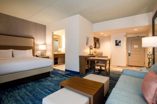 默特尔比奇Homewood Suites By Hilton Myrtle Beach Coastal Grand Mall的配有一张床和一张书桌的酒店客房