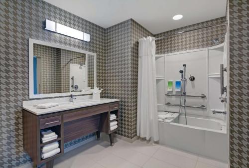 迈尔斯堡Home2 Suites by Hilton Fort Myers Colonial Blvd的一间带水槽、浴缸和淋浴的浴室