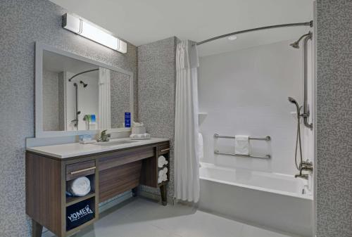 拉哥Home2 Suites By Hilton Largo, Fl的一间带水槽、浴缸和镜子的浴室