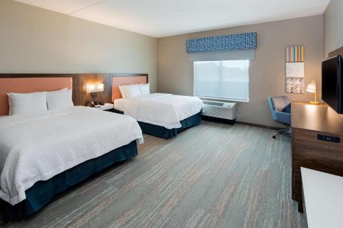 史密斯菲尔德Hampton Inn Smithfield Selma, NC的酒店客房设有两张床和电视。