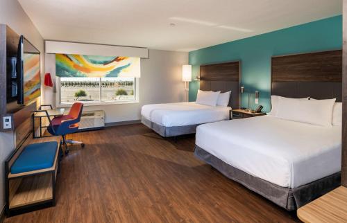 格伦代尔Tru By Hilton Phoenix Glendale Westgate的酒店客房,配有两张床和椅子