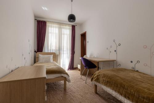 普雷代亚尔Vila Etiquette的酒店客房配有两张床和一张书桌