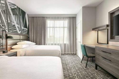 亚特兰大Embassy Suites by Hilton Atlanta Midtown的酒店客房配有两张床和一张书桌