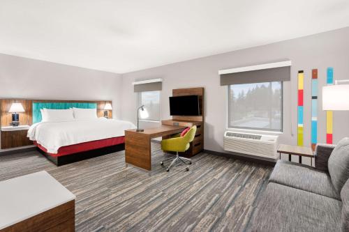 泰格德Hampton Inn & Suites Tigard的配有一张床和一张书桌的酒店客房