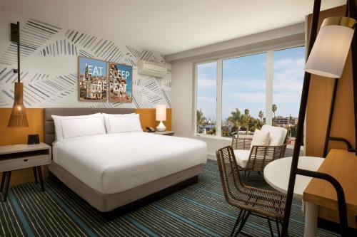 圣地亚哥The Monsaraz San Diego, Tapestry Collection By Hilton的酒店客房,配有一张床、一张桌子和椅子