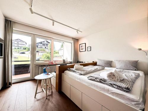上施陶芬GreenHill 2 - mit Privatsauna的一间卧室设有一张床和一个大窗户