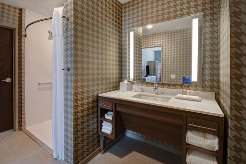 卡拉马祖Home2 Suites By Hilton Kalamazoo Downtown, Mi的一间带水槽、镜子和淋浴的浴室