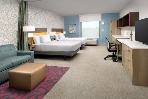 奥兰多Home2 Suites by Hilton Orlando Downtown, FL的酒店客房配有两张床和一张书桌