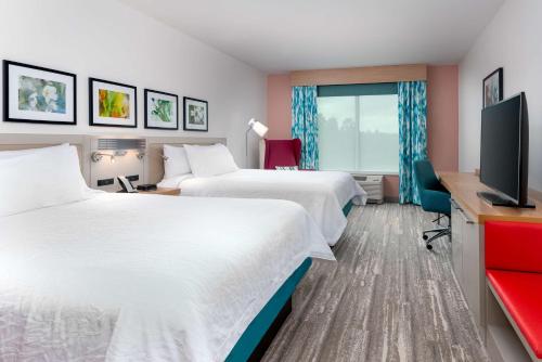 巴拿马城Hilton Garden Inn Panama City Airport, Fl的酒店客房设有两张床和一台平面电视。
