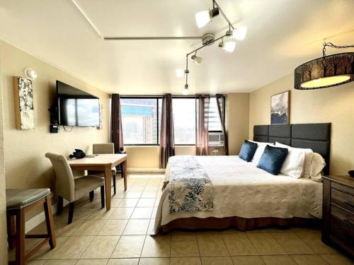 檀香山KING BED, Spacious, Legal, VIEW的一间卧室配有一张床、一张桌子和一张书桌