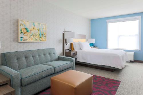 西萨克拉门托Home2 Suites By Hilton West Sacramento, Ca的酒店客房设有一张沙发和一张床