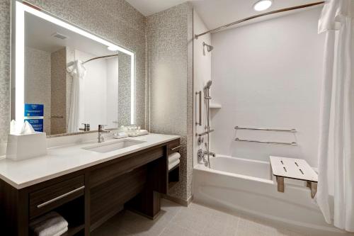 林肯郡Home2 Suites By Hilton Lincolnshire Chicago的一间带水槽、浴缸和淋浴的浴室