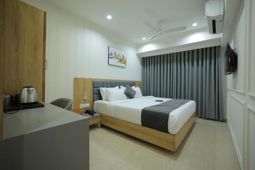 拉杰果德Hotel Shayan Inn的配有一张床和一张书桌的酒店客房