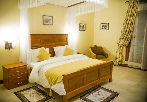 阿鲁沙Cornerstone Villas的一间卧室配有一张大床和一把椅子