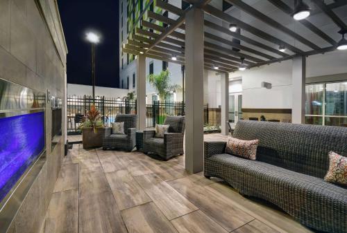 休斯顿Home2 Suites by Hilton Houston Medical Center, TX的大堂配有沙发和大屏幕电视。