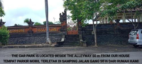 塔巴南Coliving Bali SWEET HOME Kost Lengkap di Tabanan Kota的停在石墙前的汽车