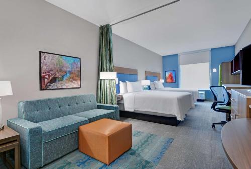 本顿维尔Home2 Suites By Hilton Bentonville Rogers的酒店客房设有一张沙发和一张床