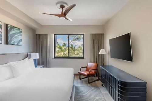 基黑Hilton Grand Vacations Club Maui Bay Villas的一间卧室配有一张床和一台平面电视