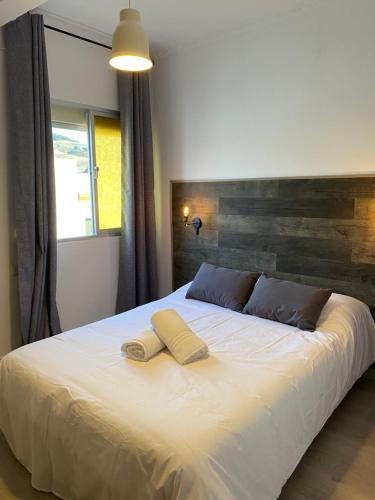 蒙地卡罗Hostal El Pinar的一间卧室配有一张大床和两条毛巾