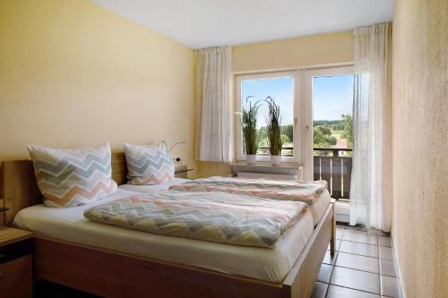 格拉芬豪森Ado Ferienwohnung的一间卧室设有一张床和一个大窗户
