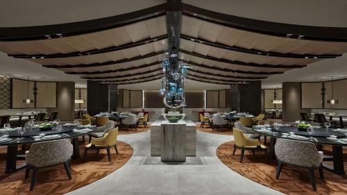 兰州兰州盛达希尔顿酒店的一间带桌椅和吊灯的用餐室