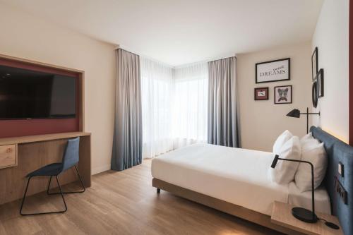 康斯坦茨Hampton by Hilton Konstanz的配有一张床和一台平面电视的酒店客房
