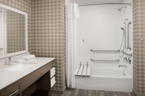 迈阿密Home2 Suites By Hilton Miami Airport South Blue Lagoon的白色的浴室设有浴缸和水槽。