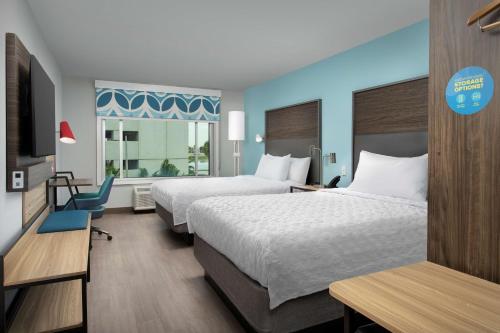 迈阿密Tru By Hilton Miami Airport South Blue Lagoon, Fl的酒店客房设有两张床和窗户。