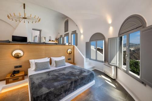 易莫洛林Eteoro Suites的一间卧室设有一张大床和大窗户