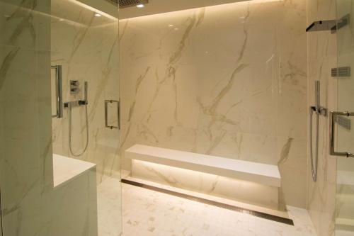 波特兰The Benson Portland, Curio Collection by Hilton的带淋浴的白色浴室和玻璃门