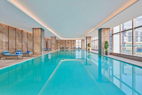 苏州苏州吴中希尔顿逸林酒店的大楼内的一个蓝色海水游泳池