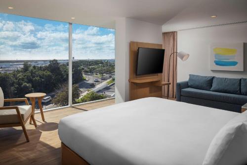 坎昆Hilton Garden Inn Cancun Airport的酒店客房设有一张床和一个大窗户