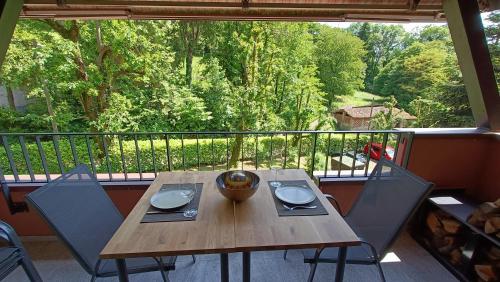 比奥焦Casa Boschetto by Quokka 360 - silent oasis in Bosco Luganese的阳台上配有一张木桌和两把椅子