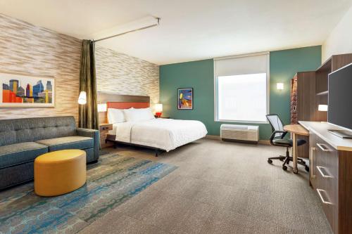 明尼阿波利斯Home2 Suites By Hilton Minneapolis University Area的酒店客房,配有床和沙发
