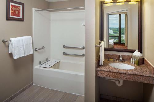 樱桃山DoubleTree by Hilton Cherry Hill Philadelphia的一间带水槽、浴缸和镜子的浴室