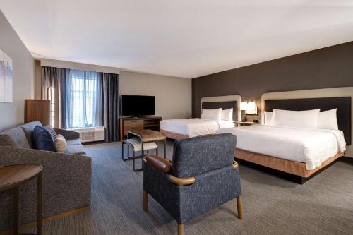 橡树溪Homewood Suites By Hilton Oak Creek Milwaukee的酒店客房设有一张大床和一张沙发。