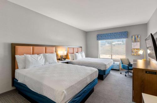 科罗拉多斯普林斯Hampton Inn Colorado Springs Northeast的酒店客房设有两张床和窗户。
