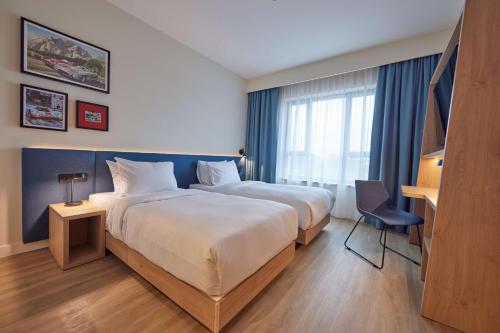 斯瓦任兹Hampton By Hilton Poznan Swarzedz的酒店客房配有两张床和一张书桌
