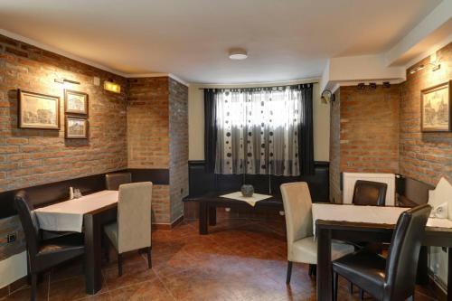莱斯科瓦茨Hotel PERLA LESKOVAC的餐厅拥有砖墙和桌椅