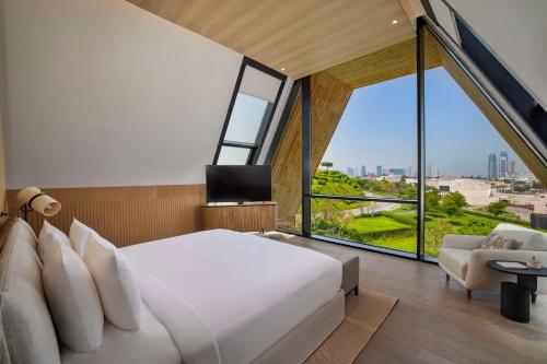 多哈Katara Hills Doha, Lxr Hotels & Resorts的一间卧室设有一张大床和一个大窗户