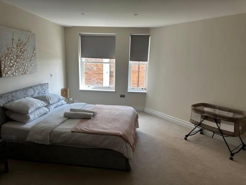伦敦Modern 1bedflat Kensington的一间卧室配有一张床、一张书桌和两个窗户。