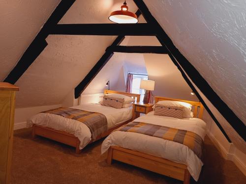 金斯坦顿Tubs Cottage的阁楼间 - 带两张床和窗户